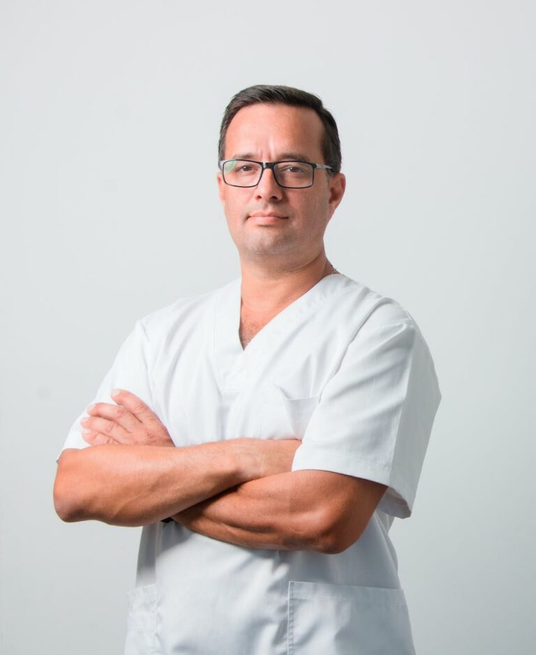 Medico del lavoro in camice bianco con le braccia conserte