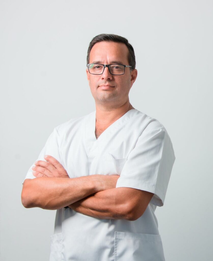 Medico del lavoro in camice bianco con le braccia conserte